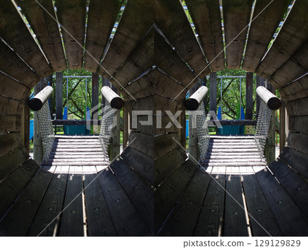 A stereogram that uses cross-sectional stereoscopic vision to recreate the sense of being inside a tunnel made of wooden playground equipment at a park. 129129829