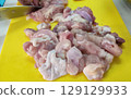 Raw Chicken Pieces on Yellow Cutting Board with Knife for Cooking in Kitchen Environment Raw Chicken Pieces on Yellow Cutting Board with Knife for Cooking in Kitchen Environment 129129933
