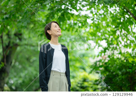 站立在新綠色的婦女 站立在新綠色的婦女 129129946