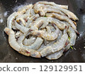 Raw Shrimp Ready for Cooking on a Dark Background with Vibrant Green Herbs Raw Shrimp Ready for Cooking on a Dark Background with Vibrant Green Herbs 129129951