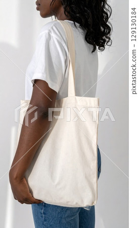 Dark Haired Woman with Natural Cotton Tote Bag in Studio in Simple Attire 129130184