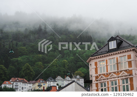 Bergen, Norway: historic architecture, mural, hillside homes in heavy fog, rainy day. 129130462