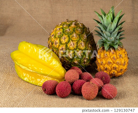 Tropical Fruit Arrangement with Pineapple Lychee and Starfruit on Burlap Background 129130747