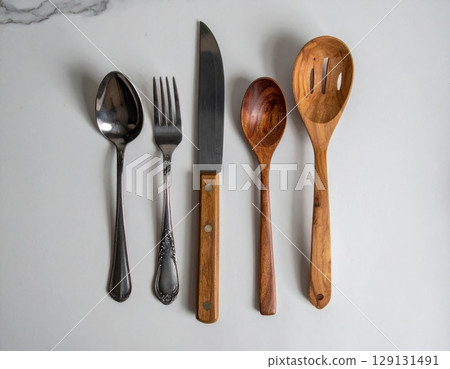 Silver Spoon Fork and Knife with Wooden Spoons on Marble Countertop Still Life 129131491