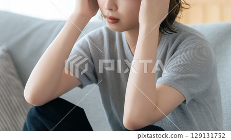 A woman holding her head in distress 129131752