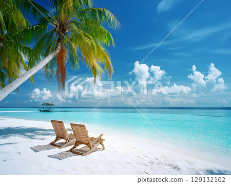 白色的沙灘、蔚藍的大海、棕櫚樹交相輝映的熱帶度假勝地。在躺椅上悠閒放鬆的夏日度假照片。 129132102