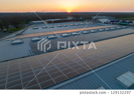 Aerial view of solar power plant with blue photovoltaic panels mounted on industrial building roof for producing green ecological electricity. Production of sustainable energy concept Aerial view of solar power plant with blue photovoltaic panels mounted on industrial building roof for producing green ecological electricity. Production of sustainable energy concept 129132297
