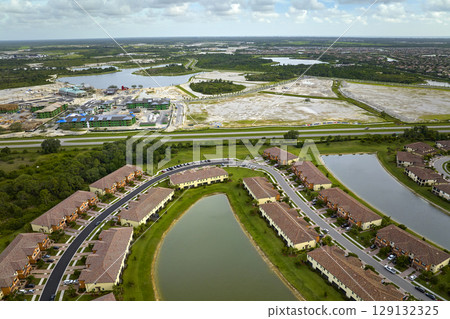 Aerial view of real estate development with tightly located family houses under construction in Florida closed suburban area. Concept of growing american suburbs 129132325
