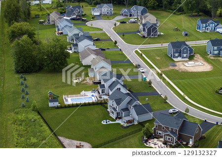 Aerial view of private residential houses in rural suburban sprawl area in Rochester, New York. Upscale suburban homes with large backyards and green grassy lawns in summer season Aerial view of private residential houses in rural suburban sprawl area in Rochester, New York. Upscale suburban homes with large backyards and green grassy lawns in summer season 129132327