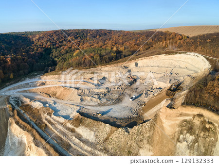 Aerial view of open pit mine of sandstone materials for construction industry with excavators and dump trucks. Heavy equipment in mining and production of useful minerals concept 129132333