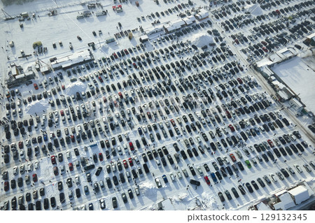 Aerial view of many cars parked for sale and people customers walking on car market or parking lot in winter Aerial view of many cars parked for sale and people customers walking on car market or parking lot in winter 129132345