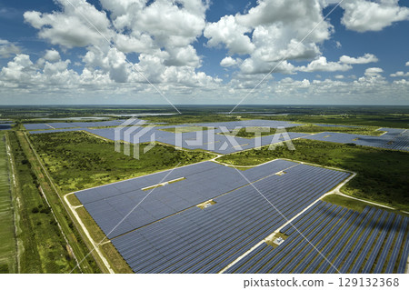 Aerial view of large sustainable electrical power plant with rows of solar photovoltaic panels for producing clean electric energy. Concept of renewable electricity with zero emission Aerial view of large sustainable electrical power plant with rows of solar photovoltaic panels for producing clean electric energy. Concept of renewable electricity with zero emission 129132368