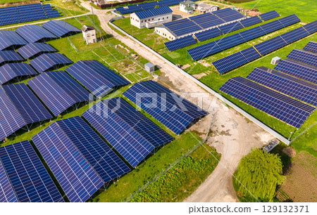 Aerial view of large sustainable electrical power plant with rows of solar photovoltaic panels for producing clean ecological electric energy. Renewable electricity with zero emission concept. 129132371