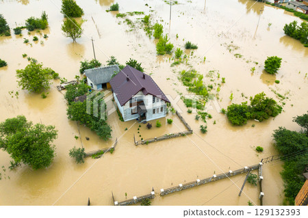 Aerial view of flooded house with dirty water all around it. 129132393