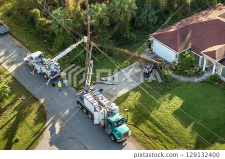 Aerial view of electrician workers repairing damaged power lines after hurricane in Florida suburban area 129132400