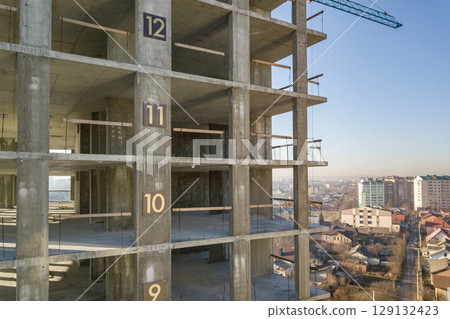 Aerial view of concrete frame of tall apartment building under construction in a city. Aerial view of concrete frame of tall apartment building under construction in a city. 129132423