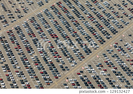 Aerial view of car factory parking lot with many brand new cars for sale. Development of American automotive industry concept Aerial view of car factory parking lot with many brand new cars for sale. Development of American automotive industry concept 129132427