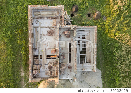 Aerial view of building site for future house, brick basement floor and stacks of brick for construction. Aerial view of building site for future house, brick basement floor and stacks of brick for construction. 129132429