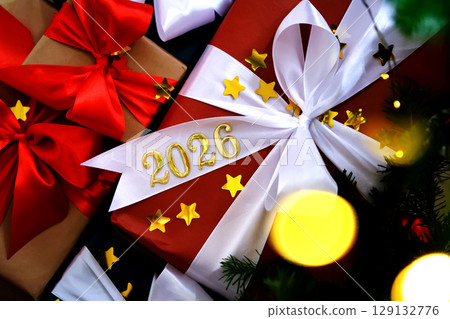 Atmospheric New Year's Eve background with the number 2026 on a Christmas present under the tree. Atmospheric New Year's Eve background with the number 2026 on a Christmas present under the tree. 129132776