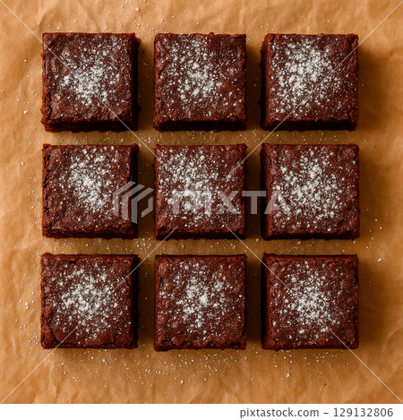 布朗尼蛋糕排成一排，上面撒上糖粉——烘焙食品的俯視圖 129132806