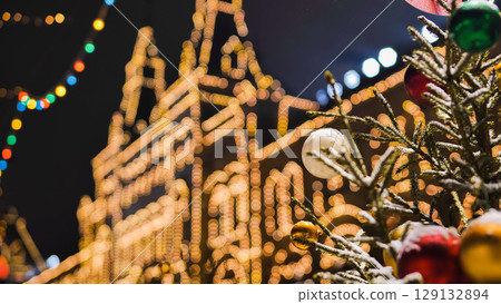 Christmas tree with colorful balls decorating Moscow GUM building at night 129132894