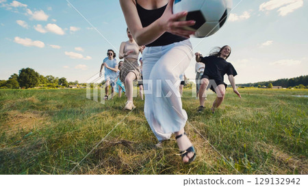 Group of teenagers running joyfully across a sunny field, playing an exciting soccer game and celebrating summer break with friends Group of teenagers running joyfully across a sunny field, playing an exciting soccer game and celebrating summer break with friends 129132942