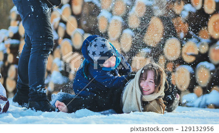 Family playing in snowy landscape, laughing together, sharing winter joy and creating lasting memories of childhood happiness 129132956