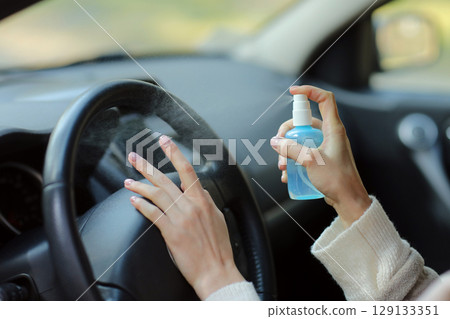 Hand of woman is spraying alcohol,disinfectant spray in car,safety,prevent infection of Covid 19 virus,coronavirus, contamination of germs or bacteria.Alcohol Sanitizer,Hygiene concept. Hand of woman is spraying alcohol,disinfectant spray in car,safety,prevent infection of Covid 19 virus,coronavirus, contamination of germs or bacteria.Alcohol Sanitizer,Hygiene concept. 129133351