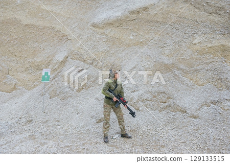 Female soldier holding rifle in snowy landscape Female soldier holding rifle in snowy landscape 129133515