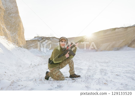Soldier training with rifle in winter shooting range 129133520