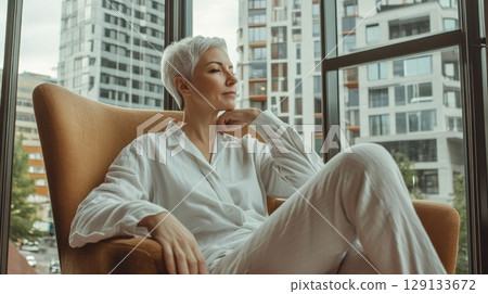 Woman in chair by window 129133672