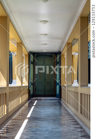 Perspective view of Hallway with Lamp ceiling and Pillars leading into entrance green ancient door at Khun Phrom Palace or Bank of Thailand Museum. Perspective view of Hallway with Lamp ceiling and Pillars leading into entrance green ancient door at Khun Phrom Palace or Bank of Thailand Museum. 129133753
