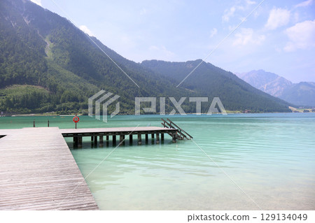 Scenic View of Achensee Lake with Wooden Pier and Alpine Landscape Scenic View of Achensee Lake with Wooden Pier and Alpine Landscape 129134049