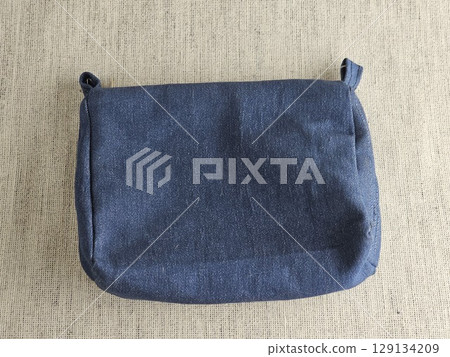 Handmade retro clutch bag on a red background. Denim bag 129134209