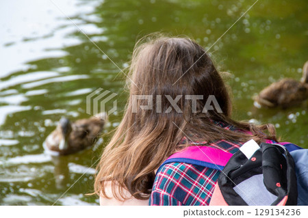 Pretty girl playing on a pond handsome teenager girl launches kite on the sea in blue sky, close up. High quality photo Pretty girl playing on a pond handsome teenager girl launches kite on the sea in blue sky, close up. High quality photo 129134236