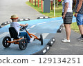 boy driving quad bike, four wheel cycle car, spring brightly morning, sunny day. High quality photo 129134251