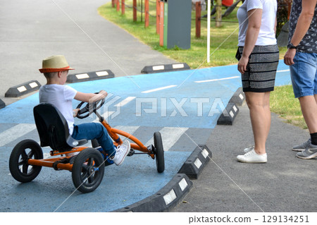 boy driving quad bike, four wheel cycle car, spring brightly morning, sunny day. High quality photo boy driving quad bike, four wheel cycle car, spring brightly morning, sunny day. High quality photo 129134251