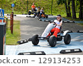 Girl driving quad bike, four wheel cycle car, spring brightly morning, sunny day. High quality photo 129134253