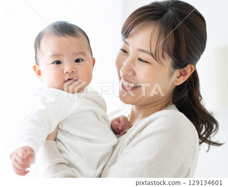 一位年輕的日本母親溫柔地抱著她的孩子微笑 129134601
