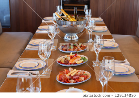 An Exquisite and Elegant Dining Setup Featuring Fine Champagne and Gourmet Culinary Delights 129134850