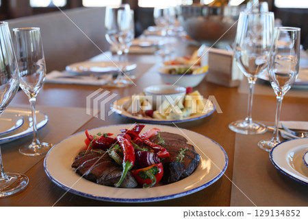 An Elegant Dining Setup Featuring a Gourmet Dish Accompanied by Exquisite Appetizers 129134852