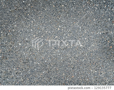 Asphalt surface background top view . Grainy road closeup. Dark gray grunge texture backdrop. 129135777