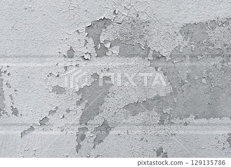 Peeling flaking paint on gray concrete wall. Cracked coating texture background. Dirty grunge surface backdrop. Repair concept. 129135786
