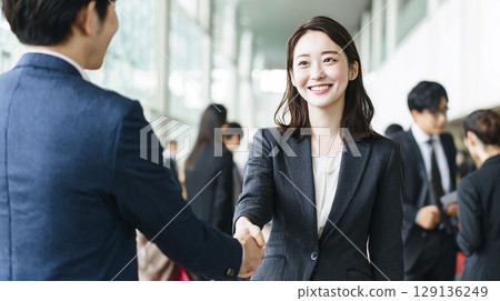 一位已被錄用並面帶微笑握手的年輕女商人（提供就業機會、工作變動、加入公司、歡迎） 129136249