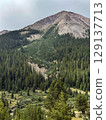 Majestic Mountain Peak Rising Above Evergreen Forest 129137713