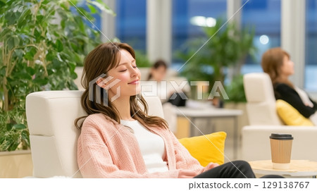 Businesswoman relaxing in the office lounge 129138767