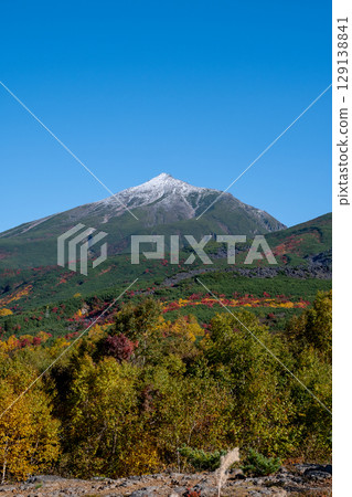 Snow-capped peak of Mt. Biei in early winter against the backdrop of blue sky 129138841