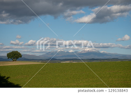 Daisetsuzan, green fields and snow-capped mountains in late autumn 129138843