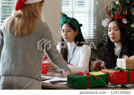 Festive Office Celebration with Colleagues in Holiday Attire and Christmas Decorations 129138882