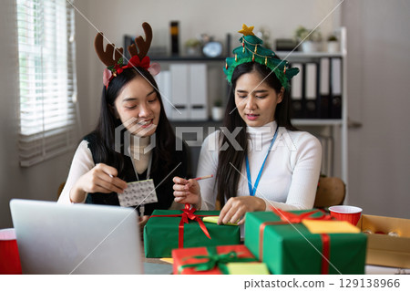 Festive Christmas Celebration with Friends Wrapping Gifts and Enjoying Holiday Cheer in a Cozy Home Setting Festive Christmas Celebration with Friends Wrapping Gifts and Enjoying Holiday Cheer in a Cozy Home Setting 129138966